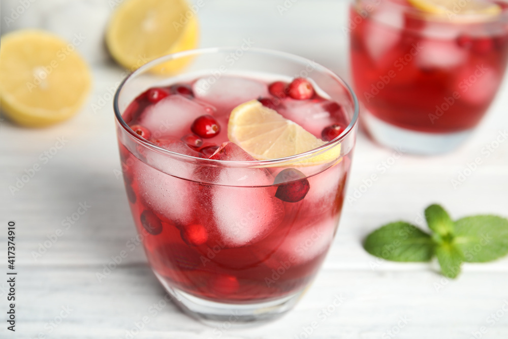 Tasty refreshing cranberry cocktail with lemon on white wooden table, closeup Tasty refreshing cranberry cocktail with lemon on white wooden table, closeup
