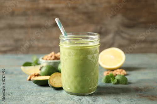 Fresh feijoa smoothie in glass on wooden table, closeup