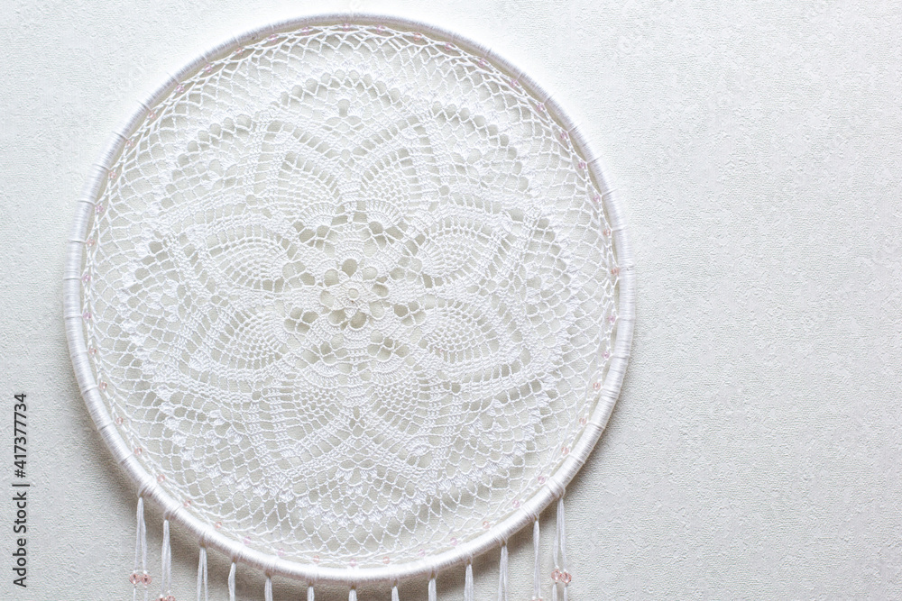 Handmade dream catcher with feathers threads and beads rope hanging on white background