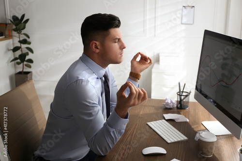 Schilderij op canvas Businessman meditating at workplace in office