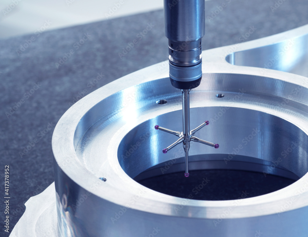 © Image Source RF - Engineering Metrology, A probe from a coordinate measurement machine taking measurements from a engineering part as part of its quality control process in manufacturing