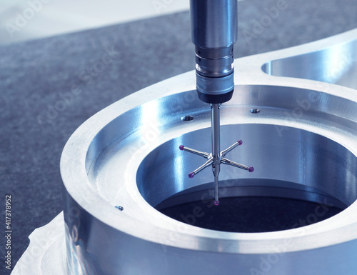 Engineering Metrology, A probe from a coordinate measurement machine taking measurements from a engineering part as part of its quality control process in manufacturing