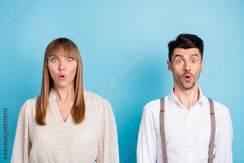 Photo of funny impressed young couple wear white outfit big eyes isolated blue color background