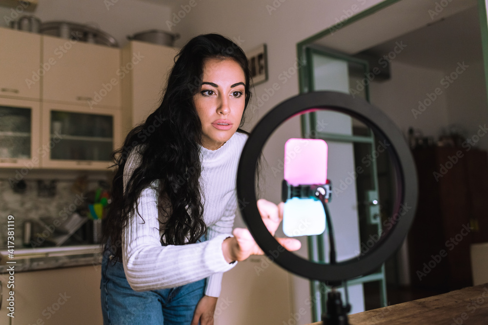 Young woman using mobile phone with ring light Young woman using mobile phone with ring light