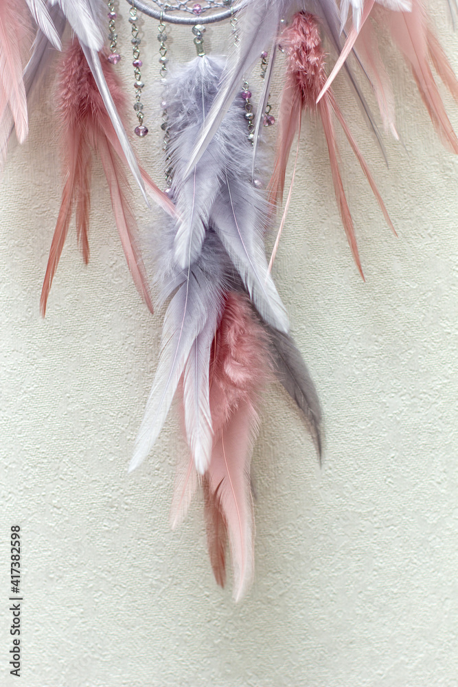 Handmade dream catcher with feathers threads and beads rope hanging on white background