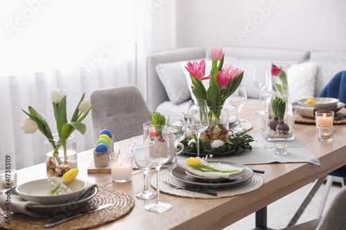 Beautiful Easter table setting with beautiful flowers in living room