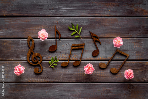 Musical wooden notes with flowers. Top view. Love songs concept