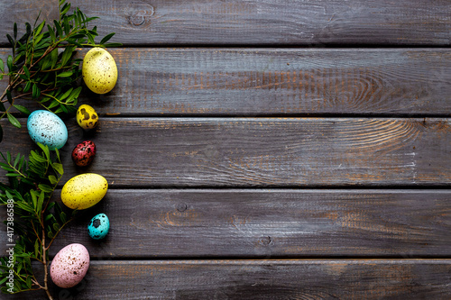 Happy Easter with colorful eggs and green branch, top view