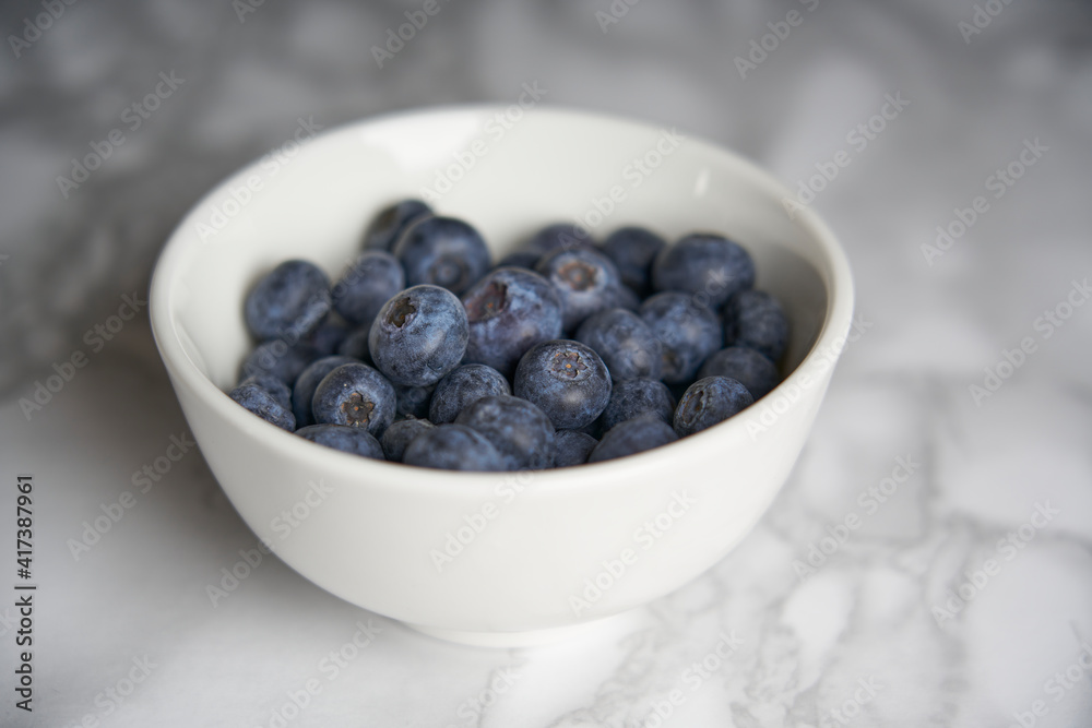 A group of fresh blueberries on a white and black marble table. A group of fresh blueberries on a white and black marble table.