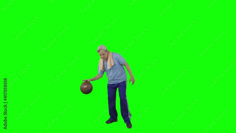 Elderly man dribbling a basketball in the studio Elderly man dribbling a basketball in the studio