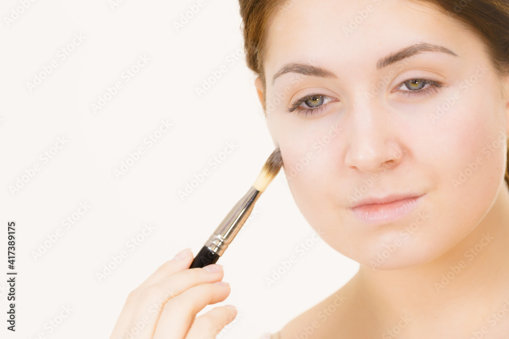Girl with no makeup holds make up brush Girl with no makeup holds make up brush