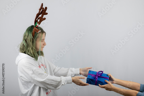 Portrait photo of a young girl model giving a present photo