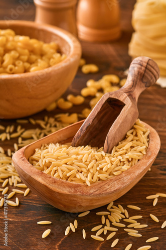 Ptititm or israeli couscous - kind of small pasta, traditional for israelian cuisine on an old wooden background. Copy space background. photo