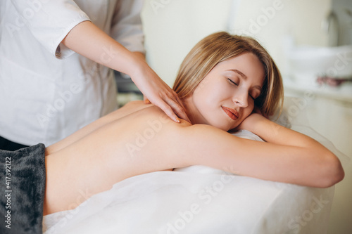 Young woman during spa salon. Woman relaxes in the spa. Spa body massage woman hands treatment.