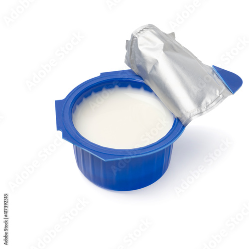 Single open blue plastic cup of coffee creamer isolated on white background