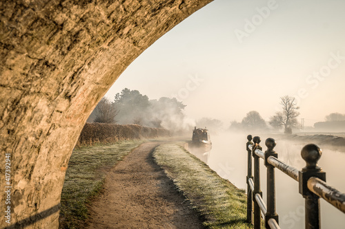 Bild auf Leinwand Stone bridge beautiful foggy misty canal narrow boat sunrise with smoke from chi