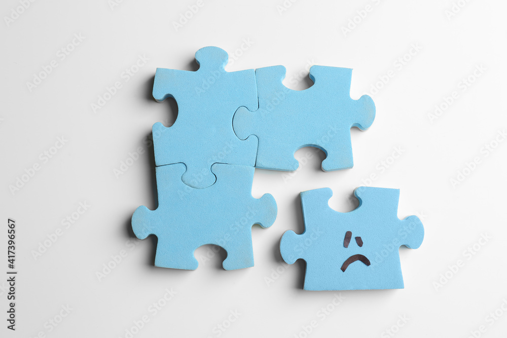 Puzzles with sad face on white background, flat lay Puzzles with sad face on white background, flat lay