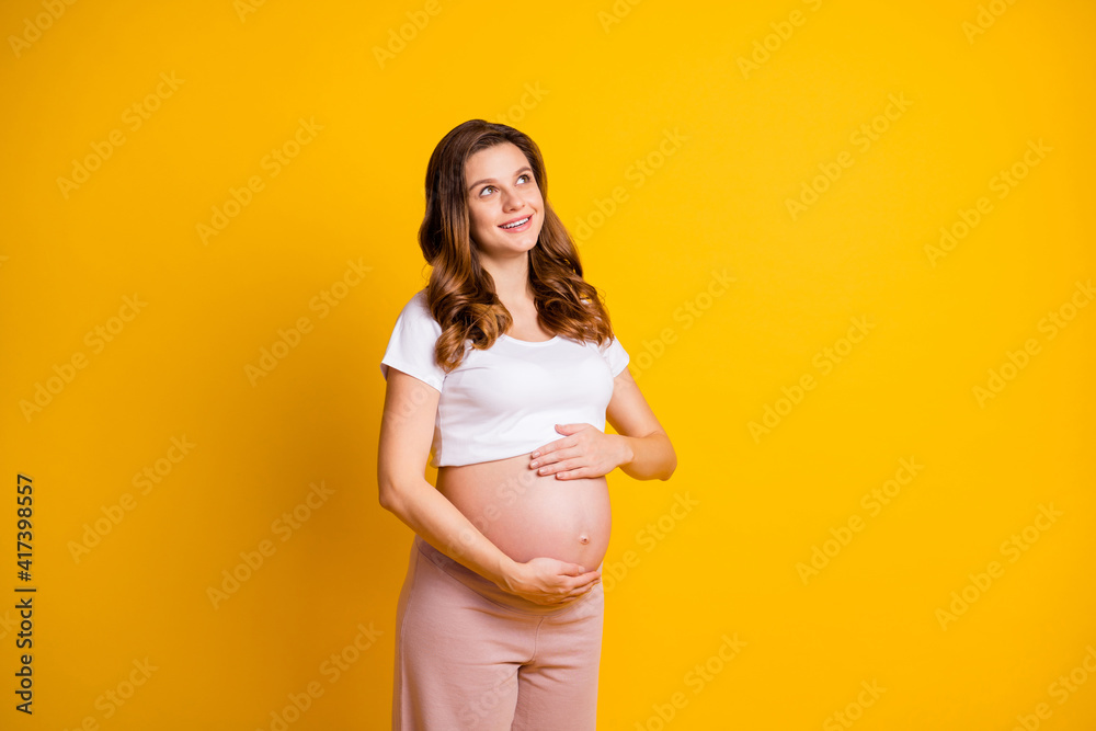 Photo of charming woman expecting child wear white outfit hugging nude belly looking empty space isolated yellow color background Photo of charming woman expecting child wear white outfit hugging nude belly looking empty space isolated yellow color background