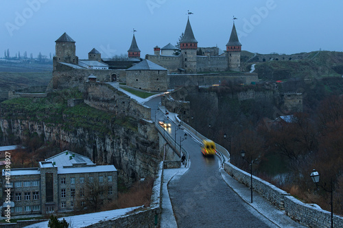 Picturesque landscape photo of medieval Kamianets-Podilskyi castle and Turkish Bridge. Famous touristic place and romantic travel destination in the city. Winter season landscape with some snow. Ukrai photo