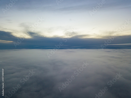 High flight above the clouds at sunset. Aerial view.