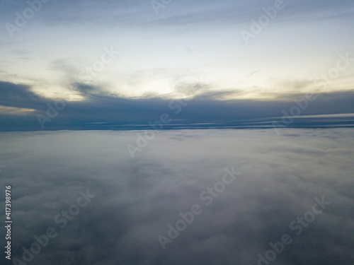 High flight above the clouds at sunset. Aerial view.
