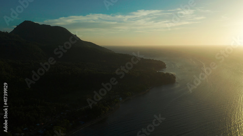 Sunset on tropical island with coast and sea, aerial view. Seascape: Ocean and sky.Philippines, Camiguin.