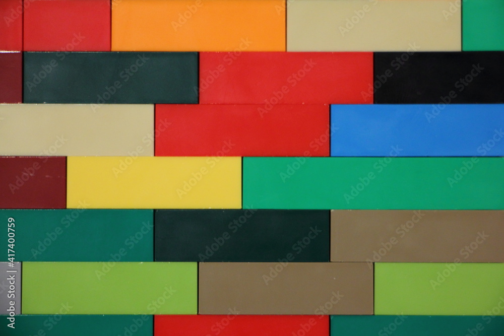 Colorful plastic bricks horizontal lines wall surface, mosaic blocks children's construction kit background texture