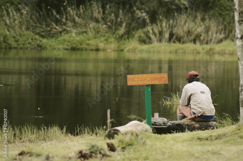 A man who is fishing in a lake, this lake is located at an altitude of about 1,700 mdpl. photo