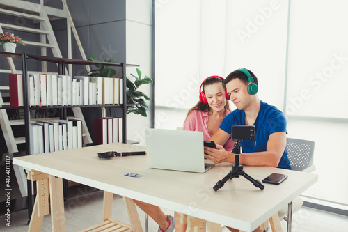 Happy young couple looking on mobile smartphone and wearing headphones