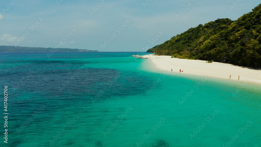 Sandy tropical beach with tourists and blue clear sea. Summer and travel vacation concept. Boracay, Philippines. Seascape with beach on tropical island. Puka shell beach