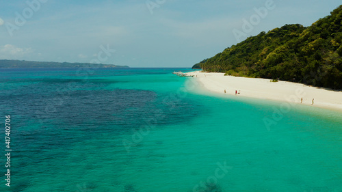 Sandy tropical beach with tourists and blue clear sea. Summer and travel vacation concept. Boracay, Philippines. Seascape with beach on tropical island. Puka shell beach