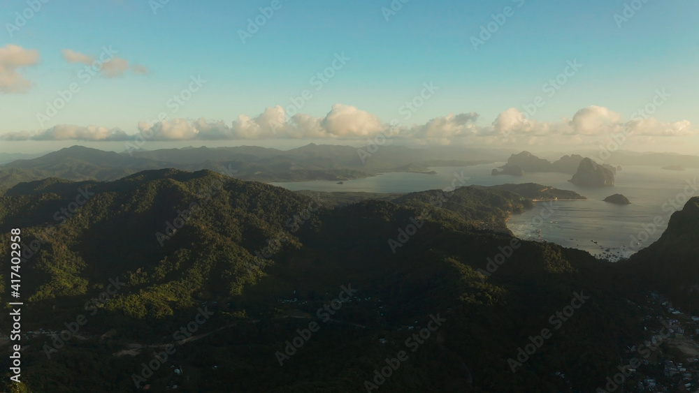 Aerial view sunset on tropical island, sea, mountains. El nido, Palawan, Philippines. Seascape, island covered with forest in the morning. Summer and travel vacation concept