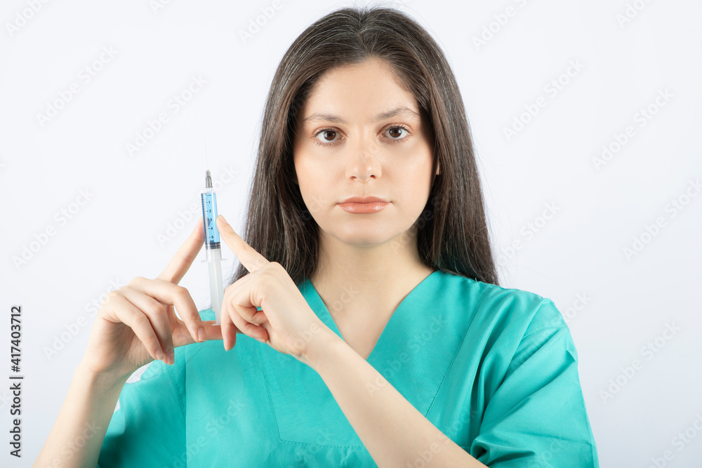 Portrait of female doctor holding a large syringe. Portrait of female doctor holding a large syringe.