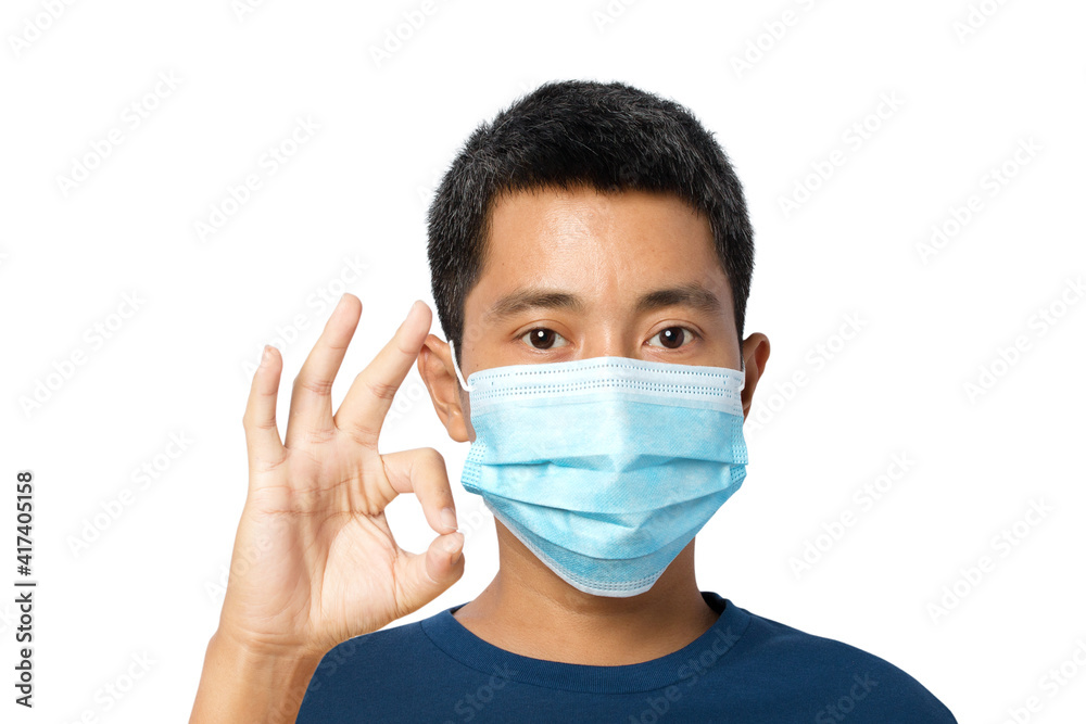 young man wearing a protective face mask with shows OK sign on white background. young man wearing a protective face mask with shows OK sign on white background.