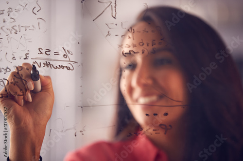 Brainstorming Businesswoman Or Mathematician Drawing Graph Calculation On Glass Screen In Office