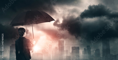 Businesswoman hold umbrella and look at cloudy sky