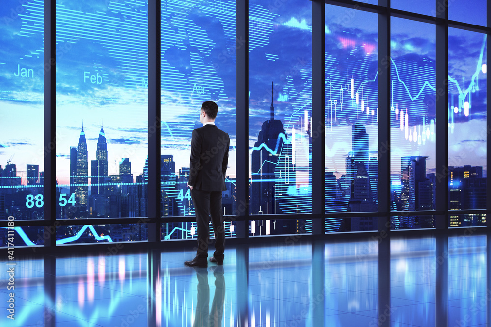 Stock market investment concept with businessman at night city background and abstract digital world map with financial graphs on the window Stock market investment concept with businessman at night city background and abstract digital world map with financial graphs on the window