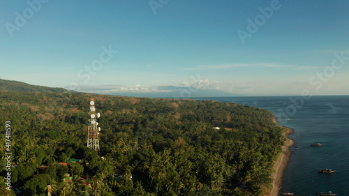Antennas and microwaves link dishes of mobile phone network and TV transmitter on telecommunication towers aerial view. Camiguin, Philippines