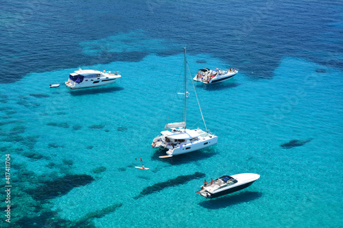 Turquoise water and floating boats in Cala D Hort bay on Ibiza