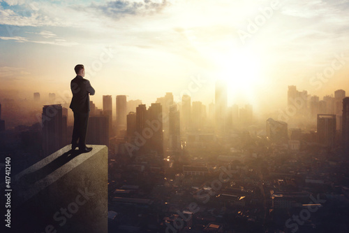 Confident businessman standing on building rooftop