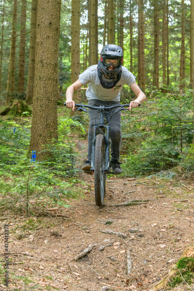 Fototapeta premium Mountainbiker befahren einen Waldtrail in einem Bikepark