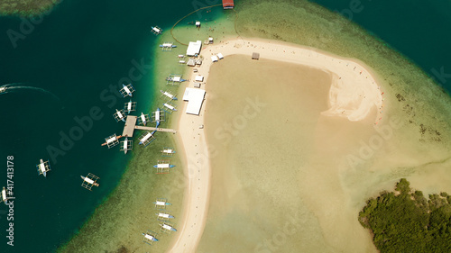 Luli island and sandy beach with tourists, sand bar surrounded by coral reef and blue sea in the honda bay, aerial drone. Tropical island and coral reef. Summer and travel vacation concept photo