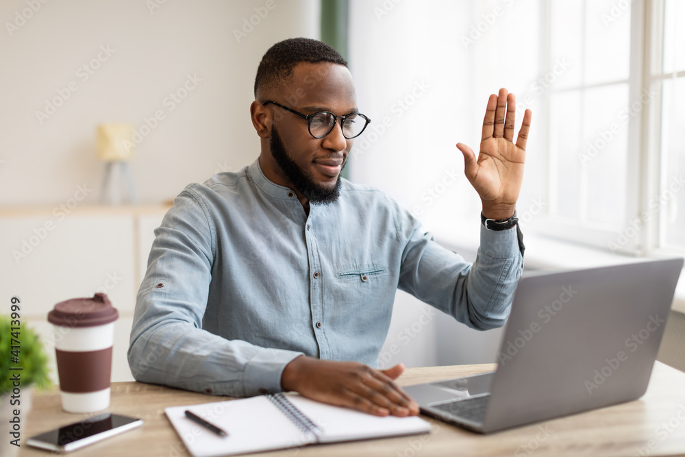 African Businessman Video Calling Waving Hello To Laptop In Office African Businessman Video Calling Waving Hello To Laptop In Office