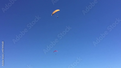 two skydivers are flying in the sky against a blue sky on a sunny, clear day.