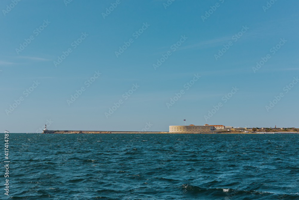 Konstantinovskaya battery, and a pier with a lighthouse at the exit from Sevastopol Bay in the Black sea