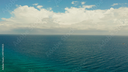 Sea surface with waves against the blue sky with clouds, aerial view. Water cloud horizon background. Blue sea water with small waves against sky. © Alex Traveler