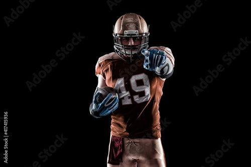 Football Player with a orange uniform coming out of a stadium tunnel.