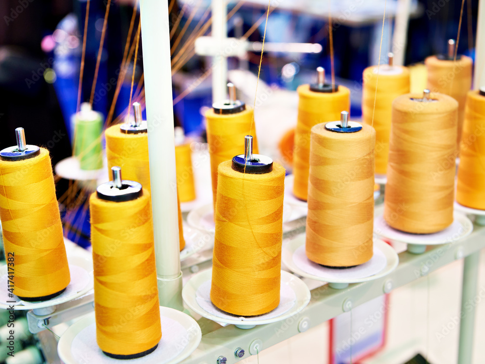 Orange spools of thread in sewing workshop Orange spools of thread in sewing workshop