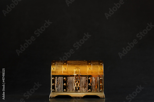 Gold treasure chest on a black textured background.