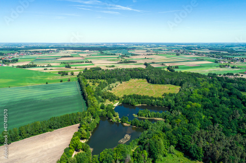 Rural landscape with a drone, numerous fields, meadows, forests and water bodies on a sunny summer day. 